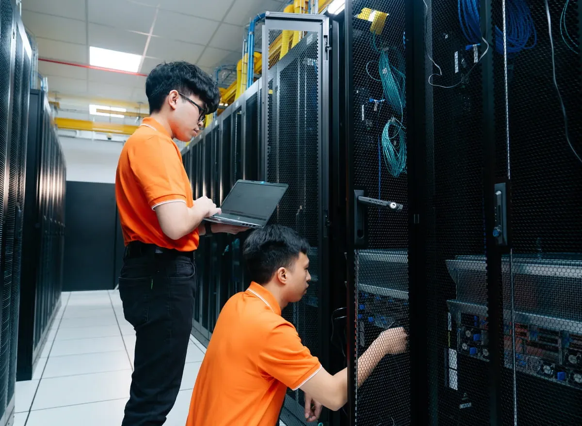 Two FPT technicians in front of server racks